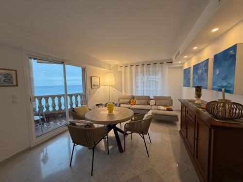a living room with a table and chairs and a couch at Lisa Apartment in Menton
