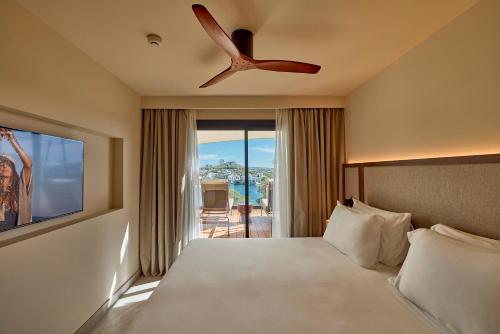 a hotel room with a bed and a ceiling fan at Purobeach Resort Santa Ponsa - New Opening in Santa Ponsa