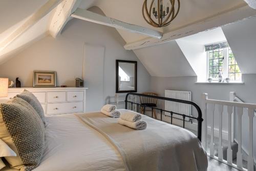 a bedroom with a bed with towels on it at 4 Court Cottages in Blockley