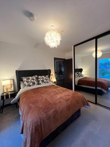 a bedroom with a large bed and a large mirror at Modern Riverside Flat in central Reading, Free Parking, Fast WiFi, Near Station in Reading