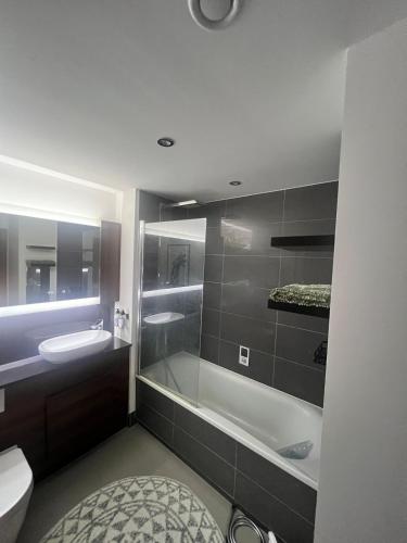 a bathroom with a tub and a toilet and a sink at Modern Riverside Flat in central Reading, Free Parking, Fast WiFi, Near Station in Reading