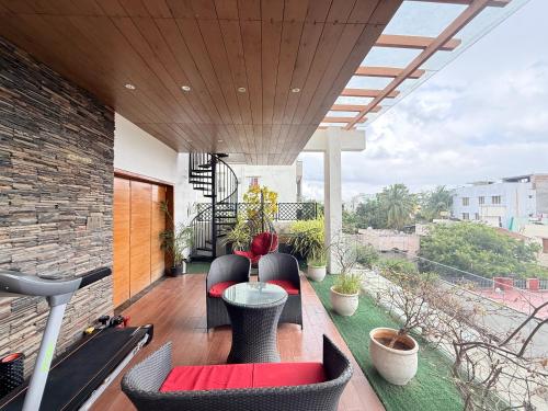 a patio with a table and chairs on a balcony at Modern Mirage 4BHK Stunning Luxury Spacez Villa in Bengaluru