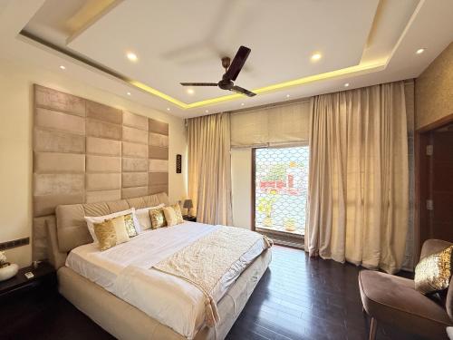 a bedroom with a large bed and a ceiling fan at Modern Mirage 4BHK Stunning Luxury Spacez Villa in Bengaluru