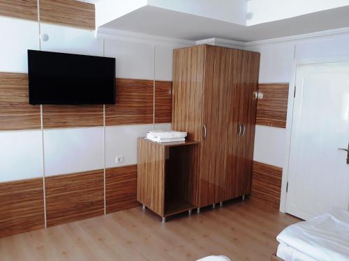 a room with a tv and a wooden cabinet at Dilmac Hotel in Gelibolu