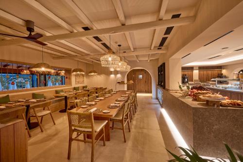 um restaurante com mesas e cadeiras de madeira e um bar em Purobeach Resort Santa Ponsa - New Opening em Santa Ponsa