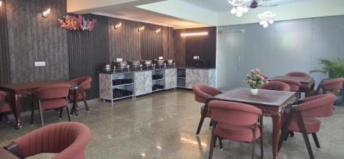a restaurant with tables and chairs in a room at Hotel Fortune Home Residency Sector 72 in Noida