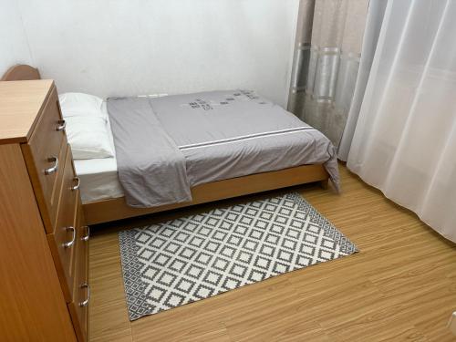 ein kleines Schlafzimmer mit einem Bett und einem Teppich in der Unterkunft Enerel tsogtsolbor in Ulaanbaatar