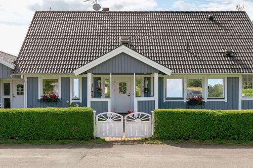 una casa azul con una puerta blanca y arbustos en Charming Swedish Villa, en Katrineholm