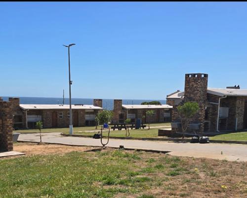 a group of buildings with a park in the foreground at Malkop Sea View Resort in Lambertʼs Bay
