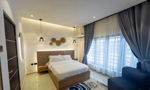 ベニンシティにあるOsaka Apartment by Js Luxuryのベッドと大きな窓のある寝室