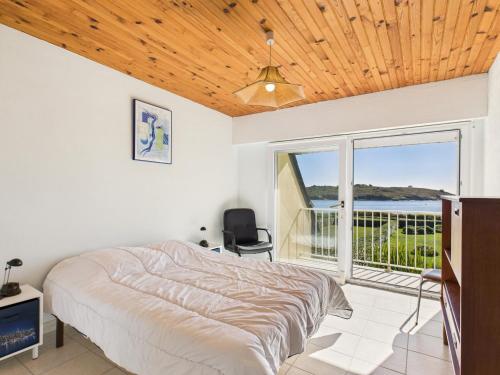 ein Schlafzimmer mit einem Bett und einem Balkon in der Unterkunft Face à la mer - Maison pour 8 avec jardin in Port Nayalo