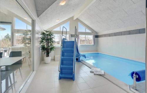 a swimming pool with a blue slide in a room at Cozy Home In Glesborg With Sauna in Fjellerup