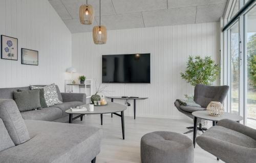a living room with a couch and a tv at Cozy Home In Glesborg With Sauna in Fjellerup