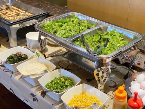 a buffet with lettuce and other food on a table at Comfort Inn Kagoshima Taniyama in Kagoshima