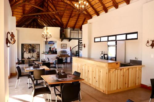 Un comedor con mesas y sillas de madera. en Grünau Chalets, en Khomas Region