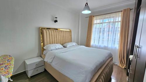 Un dormitorio con una cama grande y una ventana en Hosted by Shee -One bedroom Ruaka near Two Rivers, en Ruaka