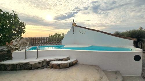 a swimming pool in a white building with at Villa Oliva São Pedro in São Pedro do Corval