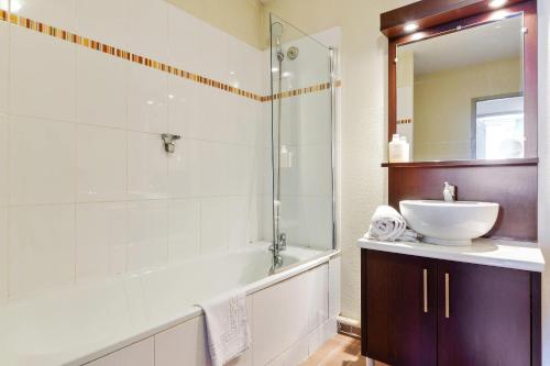 a bathroom with a tub and a sink and a shower at Comfort Aparthotel Six-Fours in Six-Fours-les-Plages
