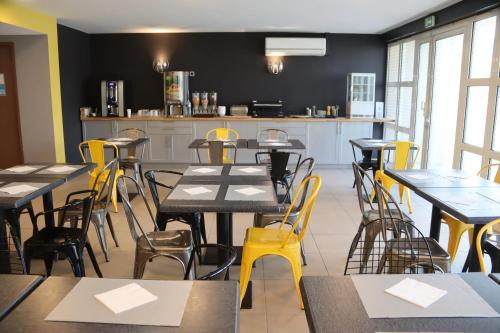 una sala da pranzo con tavoli e sedie gialle di Comfort Aparthotel Six-Fours a Six-Fours-les-Plages
