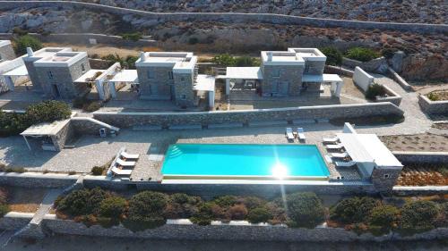 een luchtfoto van een gebouw met een zwembad bij Folegandros Villas Beachfront in Karavostasi