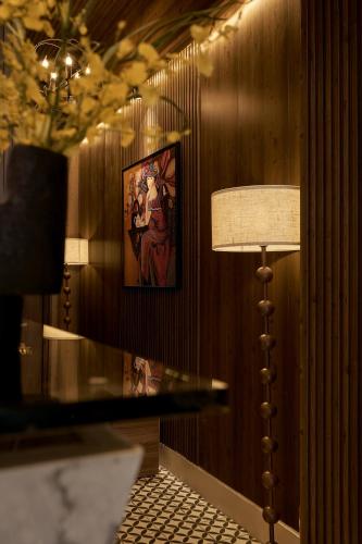 a table with a lamp and a picture on a wall at The One Premium Hotel - 1 Minute to Ben Thanh Market in Ho Chi Minh City
