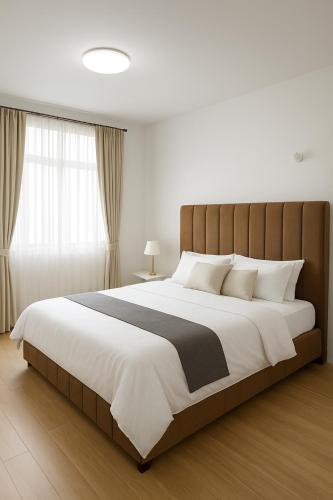 a bedroom with a large bed with white and black sheets at Book n Breeze in Nairobi