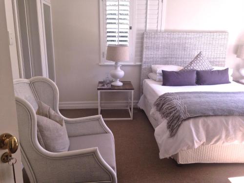 a bedroom with a bed and a chair at Southey House in Kloof