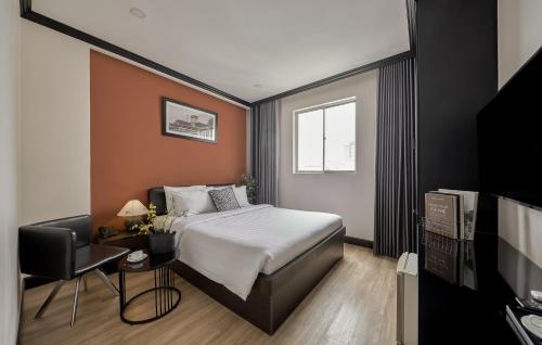 ein Hotelzimmer mit einem Bett und einem Fernseher in der Unterkunft The One Premium Hotel Spa in Ho-Chi-Minh-Stadt