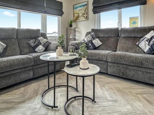 a living room with a couch and two tables at Coastal Bay View in Ayr