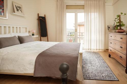 a bedroom with a bed and a dresser and a window at Tra le case di Reggio - Pisacane in Reggio Emilia