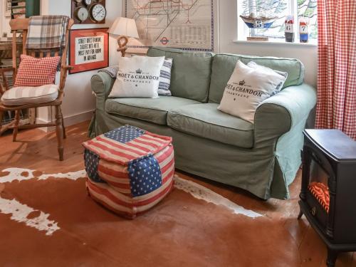 WangfordにあるAlec Hill's Bakehouseのアメリカの国旗の枕が置かれた緑のソファのあるリビングルーム