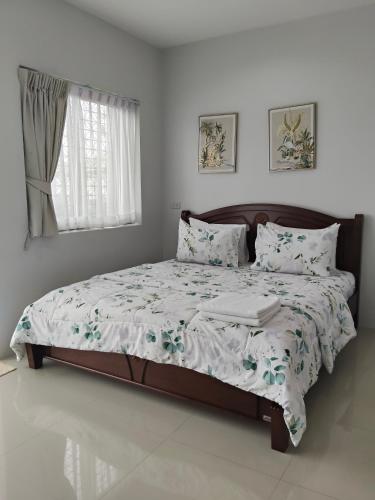 a bedroom with a large bed with a comforter and pillows at 88house suratthani in Suratthani
