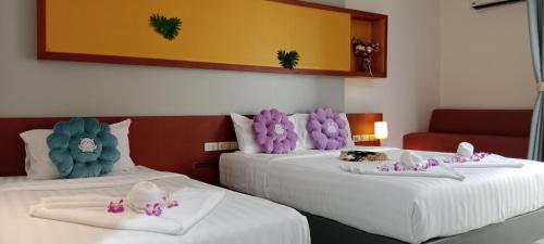 a hotel room with two beds with stuffed animals on them at Arisa Hotel Patong Beach in Patong Beach