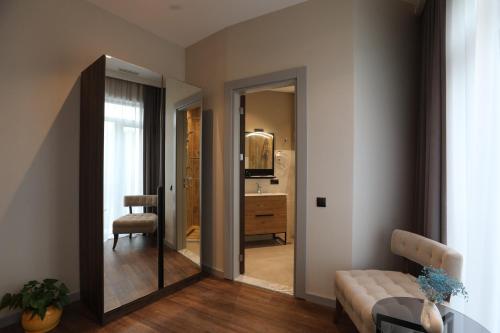 un soggiorno con un divano e uno specchio di White Hill Hotel a Tbilisi City