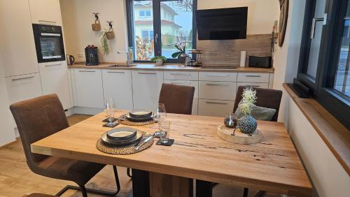 una cucina con tavolo in legno, sedie e un angolo cottura. di Wallys Auszeit a Grub am Forst