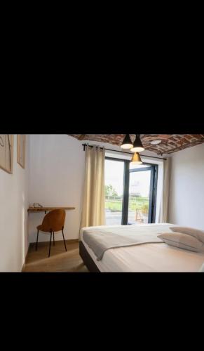 a bedroom with a bed and a window and a chair at Le Marzelheide 1 in Lontzen