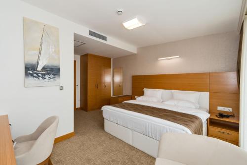 una camera d'albergo con un grande letto e una sedia di PALMIYE hotel SUITES a Istanbul