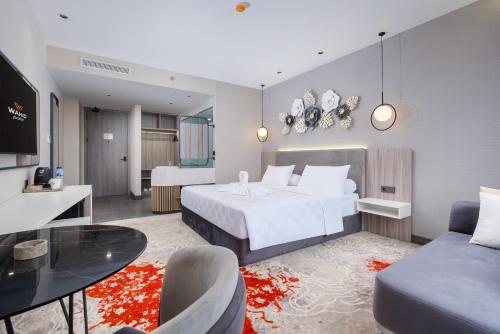 a bedroom with a bed and a table and a couch at Wahid Prime Hotel Salatiga in Salatiga