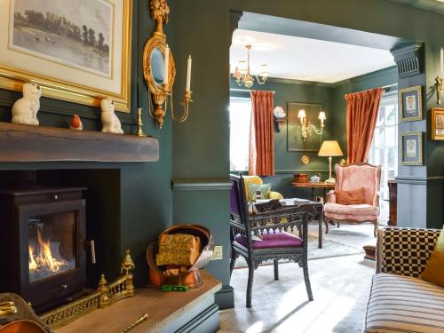 a living room with green walls and a fireplace at Russell Cottage in Flore
