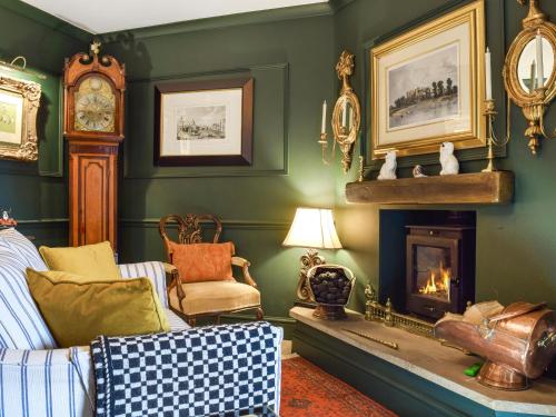 a living room with a fireplace and a grandfather clock at Russell Cottage in Flore