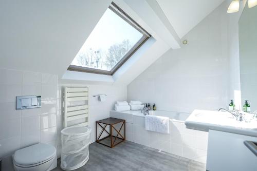 ein Bad mit einem Waschbecken, einem WC und einem Fenster in der Unterkunft La Villa du Cinéma 