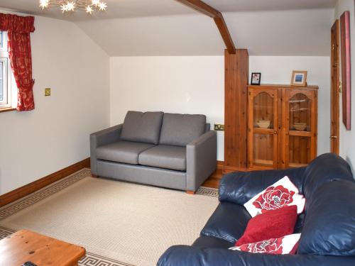 a living room with a couch and a chair at Orchardlea Apartment in Coldridge