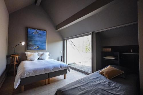 ein Schlafzimmer mit einem Bett und einem großen Fenster in der Unterkunft La Villa du Cinéma 