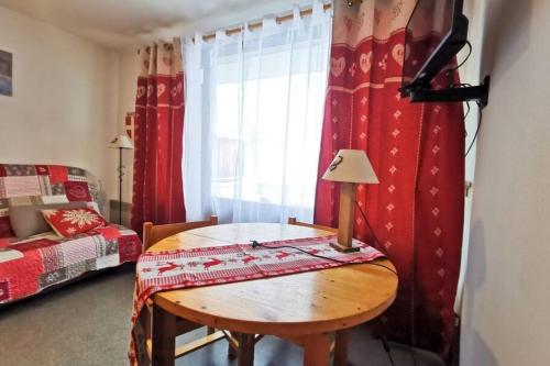 Habitación con mesa, cama y ventana en Family apartment at the foot of the slopes, en Les Déserts