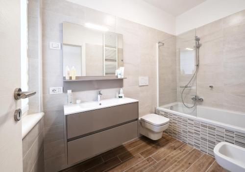 Un baño con lavabo, inodoro y bañera. en Appartamenti La Torre, en Lazise