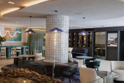 a lobby with tables and chairs and a column at Bayside Geelong Hotel & Apartments, an Ascend Collection Hotel in Geelong