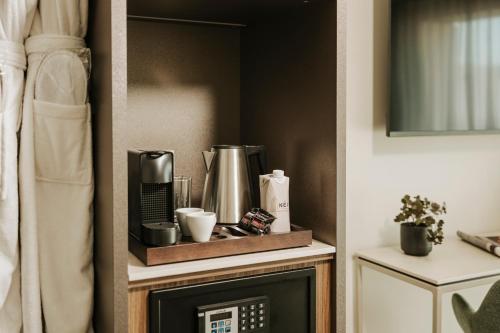 a shelf with a coffee maker on top of a fireplace at Regional Hotel by NEU Collective in Il-Gżira