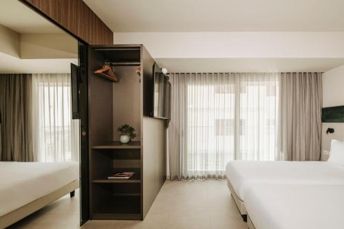 a hotel room with two beds and a window at Regional Hotel by NEU Collective in Il-Gżira