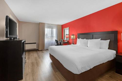 a hotel room with a large bed and a flat screen tv at Quality Inn & Suites 5585 Ambler Drive Mississauga Ontario in Mississauga