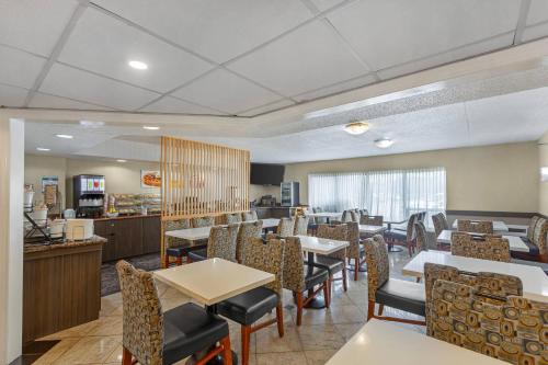 a dining room with tables and chairs in a restaurant at Quality Inn & Suites 5585 Ambler Drive Mississauga Ontario in Mississauga